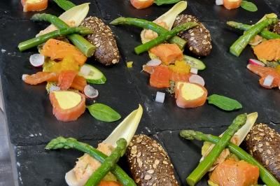 Miniature Location salle Péruwelz (Hainaut) - Le Domaine d'Arondeau #20 Assiette de mets variés avec saumon fumé, légumes et citron, servie sur une table dressée avec couverts et verres.
