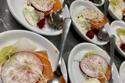 Miniature Location salle Péruwelz (Hainaut) - Le Domaine d'Arondeau #43 Assiette de mets variés avec saumon fumé, légumes et citron, servie sur une table dressée avec couverts et verres.