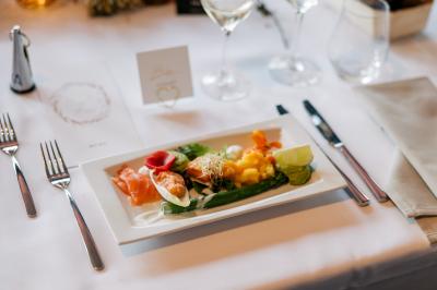 Miniature Location salle Péruwelz (Hainaut) - Le Domaine d'Arondeau #50 Assiette de mets variés avec saumon fumé, légumes et citron, servie sur une table dressée avec couverts et verres.