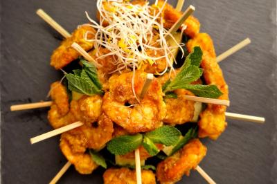 Plat dressé avec une base de viande effilochée, purée de pommes de terre, feuilles de salade et sauce en décoration.