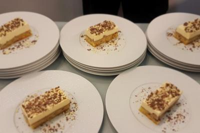 Plat dressé avec une base de viande effilochée, purée de pommes de terre, feuilles de salade et sauce en décoration.