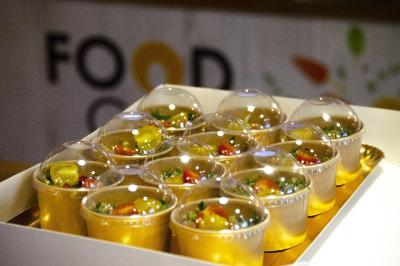 Assiette garnie de falafels dorés entourés de feuilles de salade et accompagnée de pinces en métal.