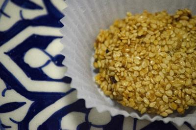 Assiette garnie de falafels dorés entourés de feuilles de salade et accompagnée de pinces en métal.