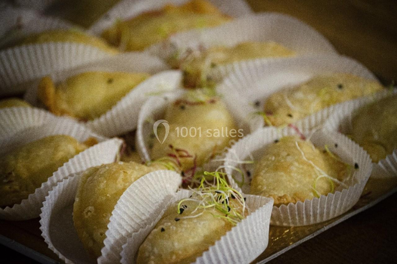 Assortiment de petits chaussons dorés garnis, présentés dans des caissettes en papier, décorés de pousses fraîches.