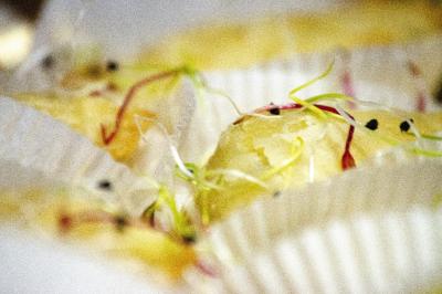 Assiette garnie de falafels dorés entourés de feuilles de salade et accompagnée de pinces en métal.