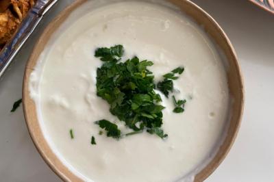 Assiette garnie de falafels dorés entourés de feuilles de salade et accompagnée de pinces en métal.