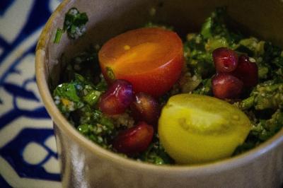 Assiette garnie de falafels dorés entourés de feuilles de salade et accompagnée de pinces en métal.