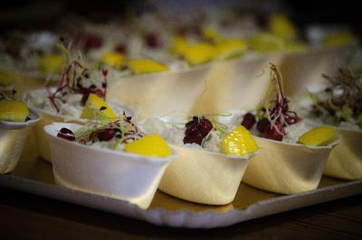 Assiette garnie de falafels dorés entourés de feuilles de salade et accompagnée de pinces en métal.