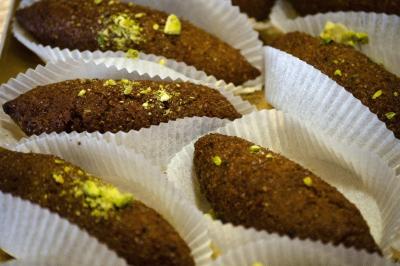 Assiette garnie de falafels dorés entourés de feuilles de salade et accompagnée de pinces en métal.