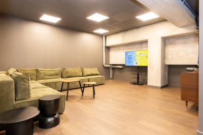 Poste de jeu interactif avec quatre boutons jaunes et un écran affichant ’Quiz Room’ dans un éclairage bleu.