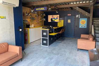 Salle de quiz interactive avec plusieurs bornes équipées d'écrans tactiles et de buzzers jaunes.