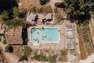 Fête nocturne en plein air avec un bar central, des invités debout et des lumières colorées sous une tente éclairée.