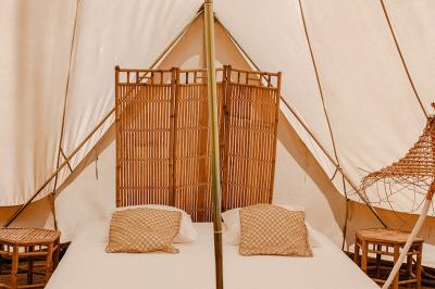 Fête nocturne en plein air avec un bar central, des invités debout et des lumières colorées sous une tente éclairée.