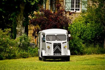 Fête nocturne en plein air avec un bar central, des invités debout et des lumières colorées sous une tente éclairée.