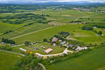 Fête nocturne en plein air avec un bar central, des invités debout et des lumières colorées sous une tente éclairée.