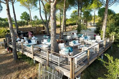 Fête nocturne en plein air avec un bar central, des invités debout et des lumières colorées sous une tente éclairée.
