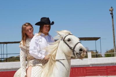 Fête nocturne en plein air avec un bar central, des invités debout et des lumières colorées sous une tente éclairée.