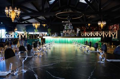 Enceinte noire fixée sur un poteau en bois, entourée de feuillage, sous un ciel bleu dégagé.