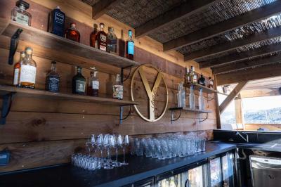 Enceinte noire fixée sur un poteau en bois, entourée de feuillage, sous un ciel bleu dégagé.