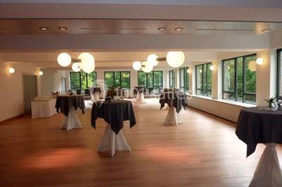 Quatre voitures sportives colorées alignées sur un parking en plein air, entourées de verdure.