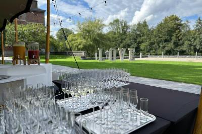 Quatre voitures sportives colorées alignées sur un parking en plein air, entourées de verdure.