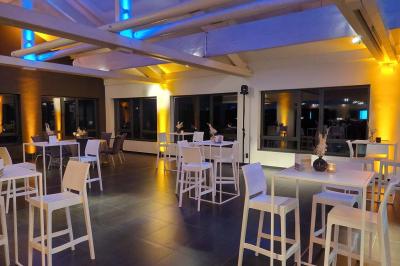 Quatre voitures sportives colorées alignées sur un parking en plein air, entourées de verdure.