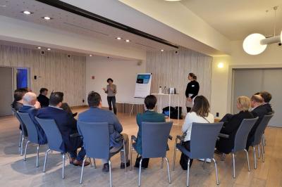 Quatre voitures sportives colorées alignées sur un parking en plein air, entourées de verdure.