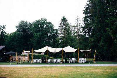 Quatre voitures sportives colorées alignées sur un parking en plein air, entourées de verdure.