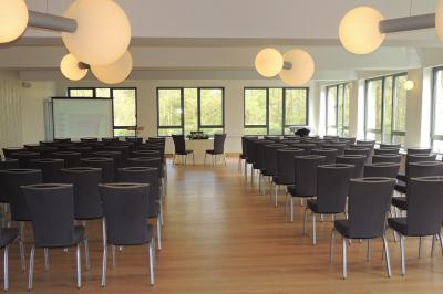 Quatre voitures sportives colorées alignées sur un parking en plein air, entourées de verdure.