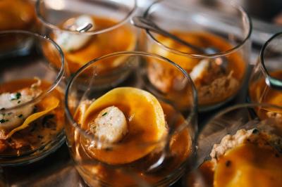 Quatre voitures sportives colorées alignées sur un parking en plein air, entourées de verdure.