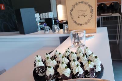 Quatre voitures sportives colorées alignées sur un parking en plein air, entourées de verdure.