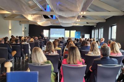 Quatre voitures sportives colorées alignées sur un parking en plein air, entourées de verdure.