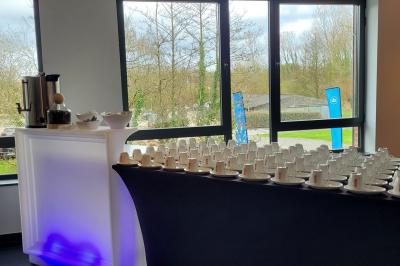 Quatre voitures sportives colorées alignées sur un parking en plein air, entourées de verdure.