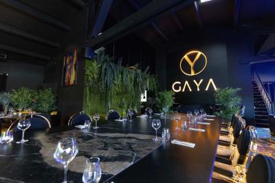 Artiste jonglant avec des torches enflammées dans une ambiance sombre, devant un logo lumineux en arrière-plan.