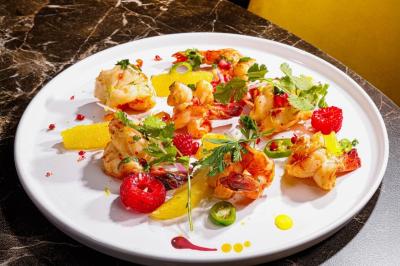 Artiste jonglant avec des torches enflammées dans une ambiance sombre, devant un logo lumineux en arrière-plan.