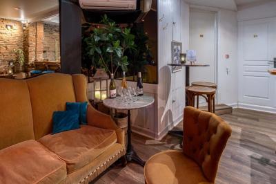 Salle avec un baby-foot, un mur en briques, un comptoir avec tabourets et une baie vitrée donnant sur la rue.