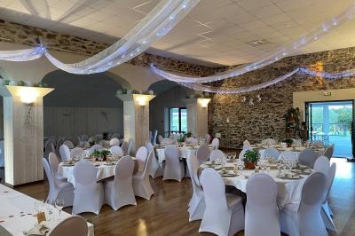 Table dressée avec des verres et un seau à champagne devant une baie vitrée, logo ’Aux Saveurs du Jour’ au mur.