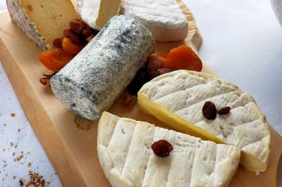 Table dressée avec des verres et un seau à champagne devant une baie vitrée, logo ’Aux Saveurs du Jour’ au mur.