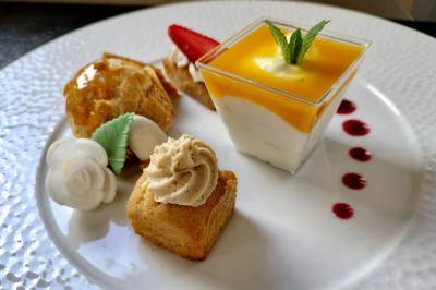 Table dressée avec des verres et un seau à champagne devant une baie vitrée, logo ’Aux Saveurs du Jour’ au mur.