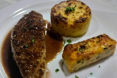 Table dressée avec des verres et un seau à champagne devant une baie vitrée, logo ’Aux Saveurs du Jour’ au mur.