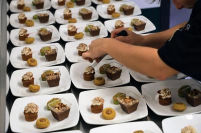Table dressée avec des verres et un seau à champagne devant une baie vitrée, logo ’Aux Saveurs du Jour’ au mur.