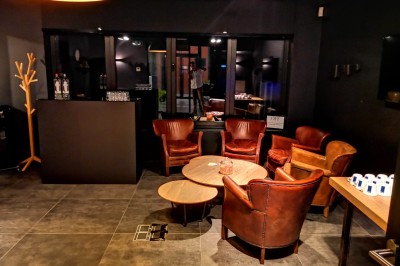 Lavabo moderne avec robinet chromé, serviettes blanches pliées et produits de toilette sur un plan en bois.