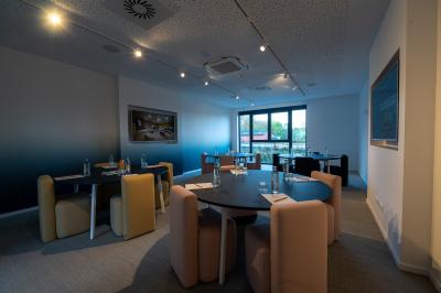 Exposition de véhicules Range Rover et Jaguar dans un showroom éclairé avec des fiches techniques visibles.