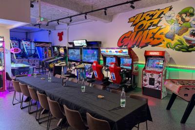 Cuisine moderne avec plancher en bois, tables hautes, chaises noires, réfrigérateur, micro-ondes et cafetière.