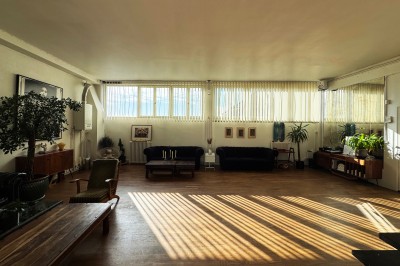 Rideaux rouges fermés dans une pièce lumineuse avec des échantillons de tissus colorés alignés sur la gauche.