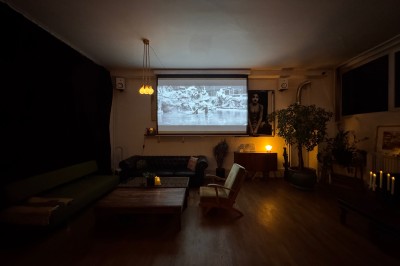 Rideaux rouges fermés dans une pièce lumineuse avec des échantillons de tissus colorés alignés sur la gauche.
