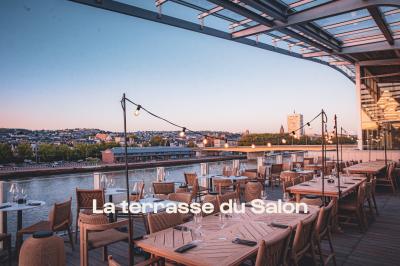 Lustre en cristal suspendu, éclairé, avec un fond sombre et des rideaux texturés.