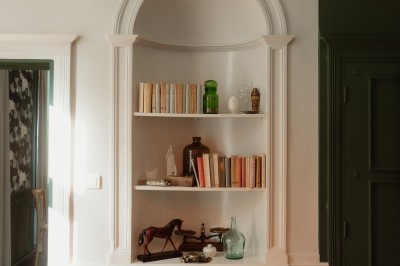 Chambre avec lit double, mur décoré de motifs géométriques bleus et blancs, lumière naturelle entrant par une fenêtre.
