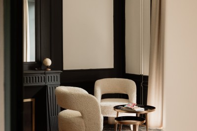 Chambre avec lit double, mur décoré de motifs géométriques bleus et blancs, lumière naturelle entrant par une fenêtre.