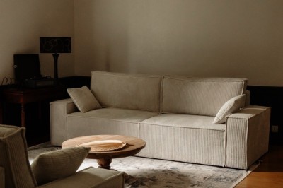 Chambre avec lit double, mur décoré de motifs géométriques bleus et blancs, lumière naturelle entrant par une fenêtre.